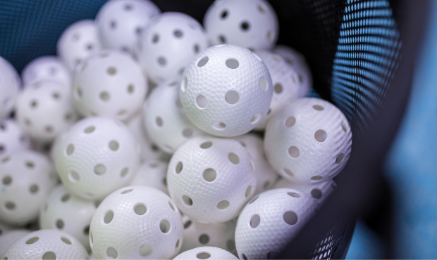 Foto på många vita innebandybollar.