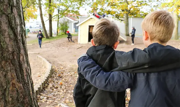 Två kompisar som håller om varandra. 