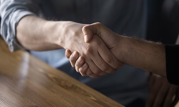 Närbild på ett handslag.