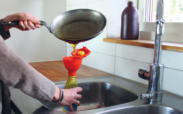 Foto på en person som häller olja från en stekpanna ner i miljötratten.