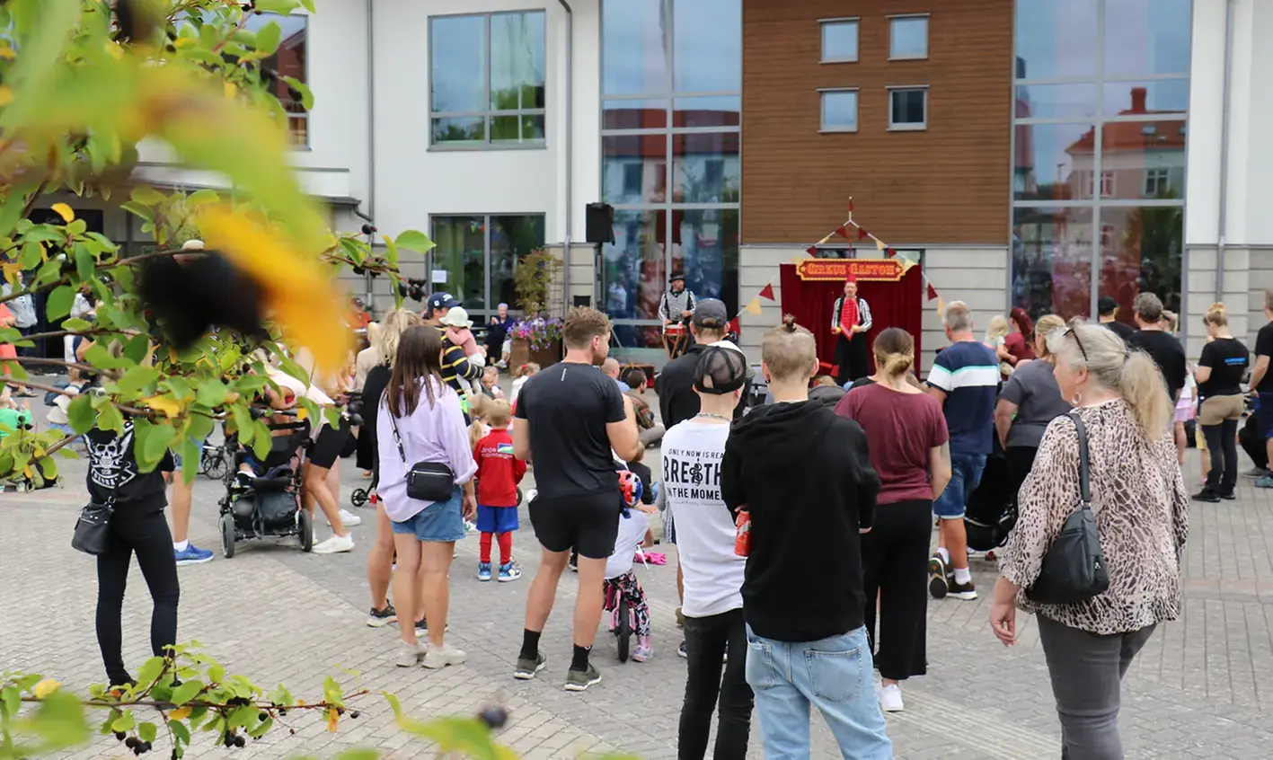 Publik på torget utanför Kulturhuset där en gatucirkus har föreställning. 